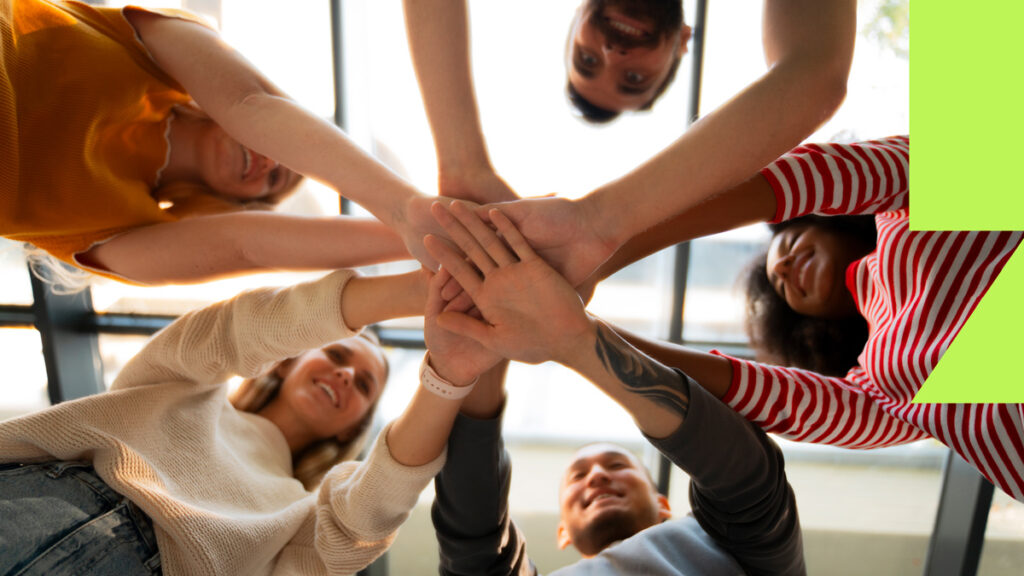 Equipe de trabalho dando as mãos, criando relacionamentos no ambiente de trabalho.