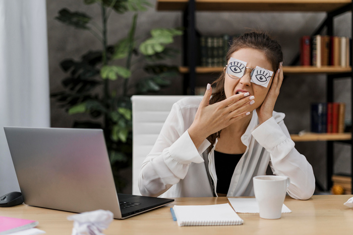 Profissional com sono em horário comercial devido a excesso de trabalho.