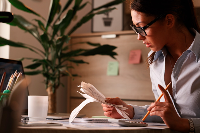 Profissional analisando documentos e cálculos, ilustrando a segurança do endereço fiscal para empresas.