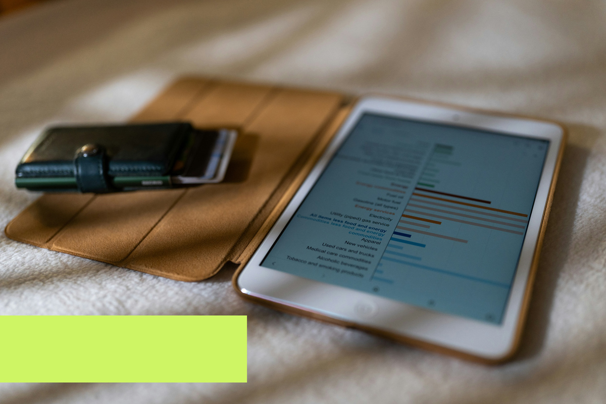 Tablet exibindo gráficos de finanças e carteira ao lado, representando análise de endividamento de empresas e planejamento financeiro.