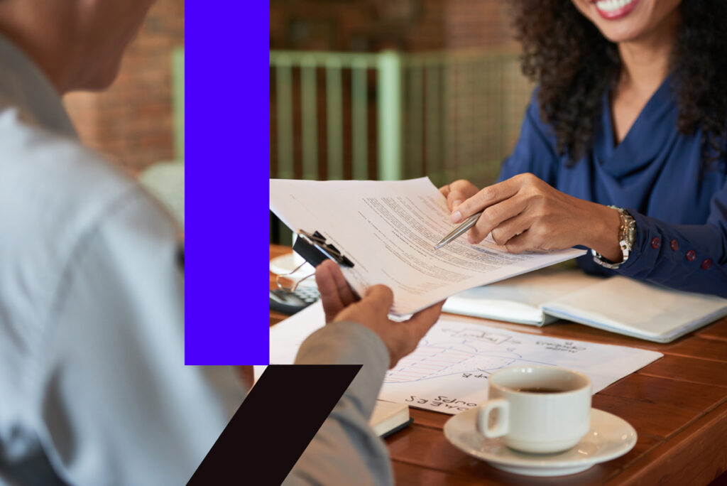 Consultor explicando contrato a clientes, representando tomada de decisão consciente e busca por autonomia profissional.