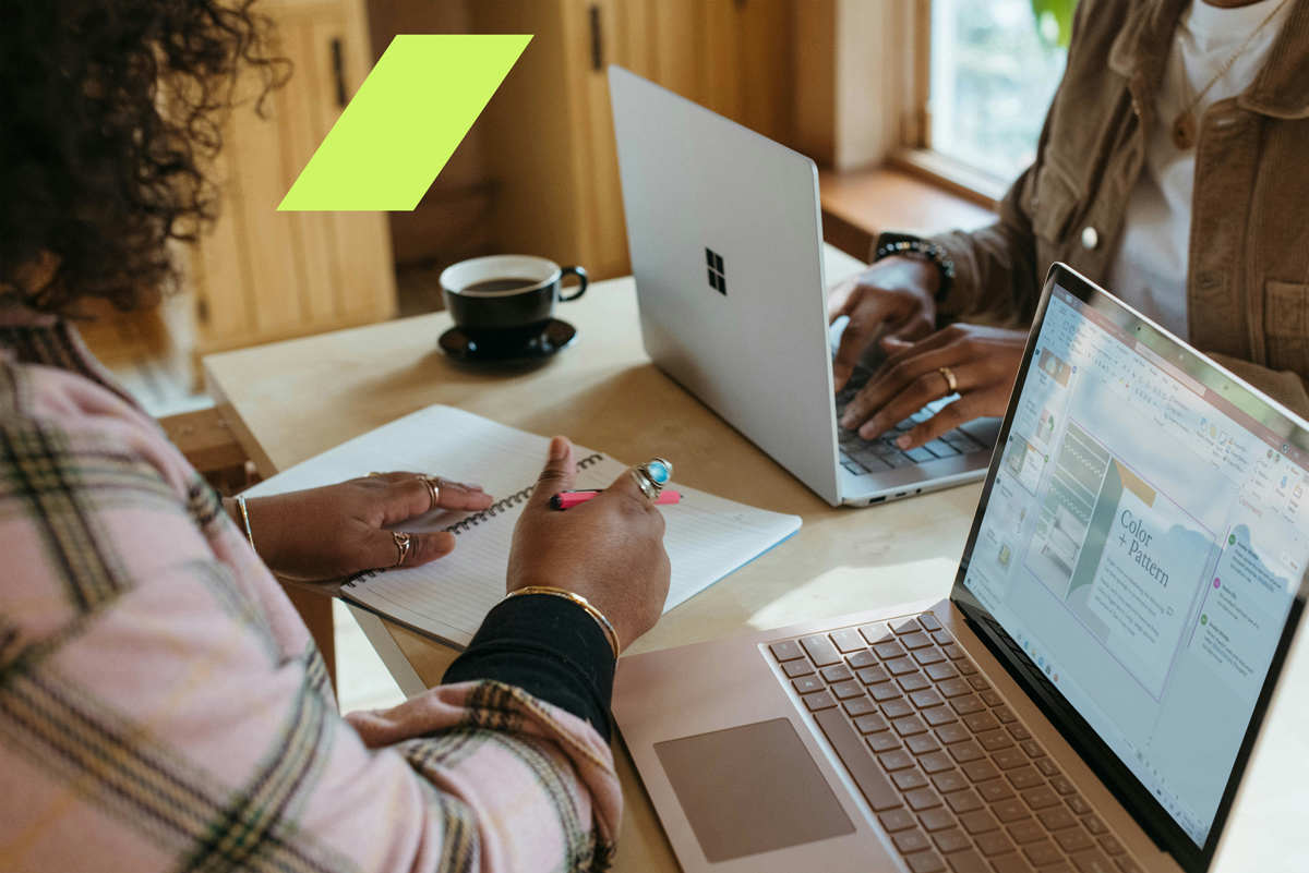 Profissionais colaborando em reunião com laptops e anotações, representando a troca de ideias no ecossistema empreendedor.