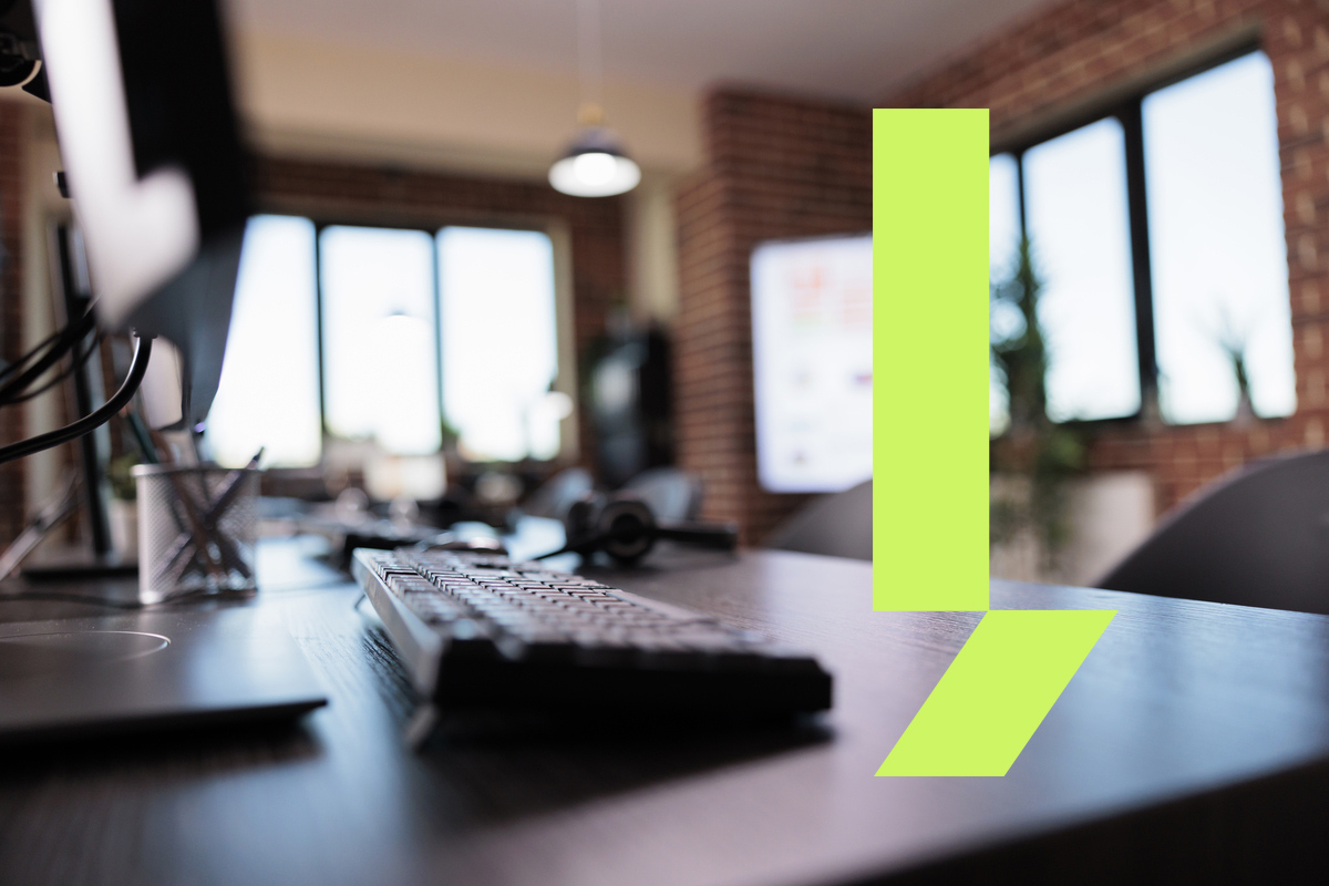 Mesa de escritório com teclado, headset e iluminação natural ao fundo, ilustrando a locação de sala por hora em espaços profissionais prontos para uso e com infraestrutura completa.