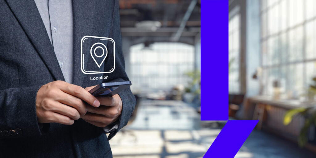 Profissional usando o smartphone em ambiente corporativo, ilustrando a diferença entre endereço fiscal e endereço comercial na formalização de empresas.