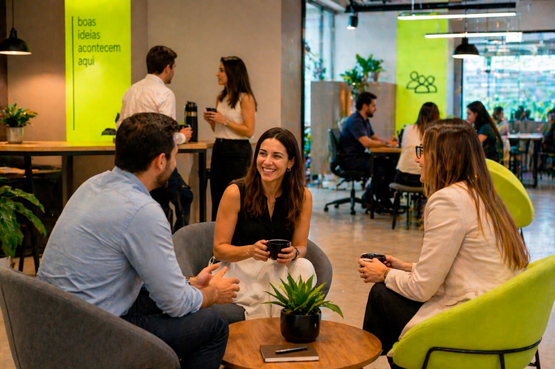 Equipe reunida em coworking trocando ideias em ambiente descontraído.