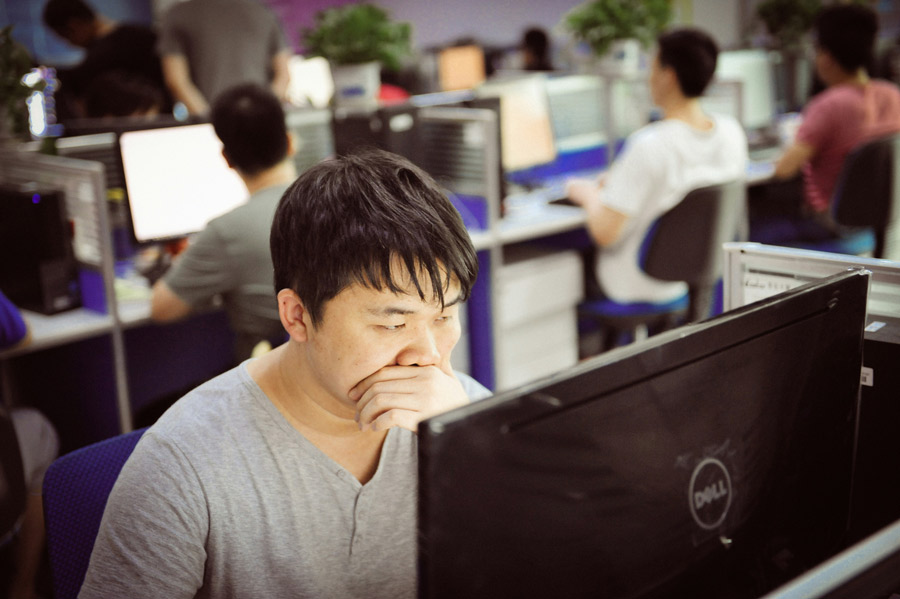 Homem trabalhando em computador visivelmente cansado e preocupado